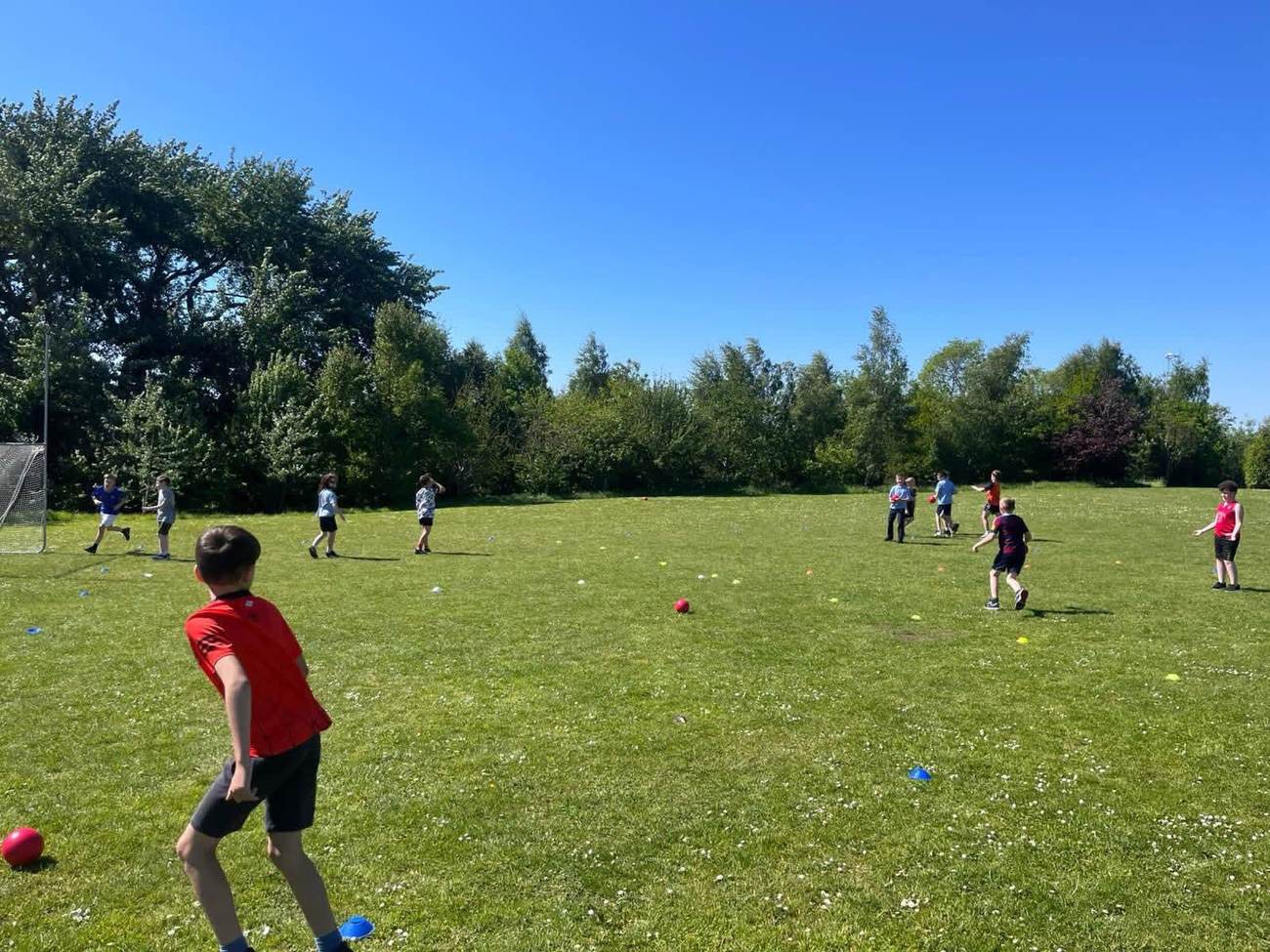 Children playing dodgeball outdoors on a sunny day during an Elevate Sports party