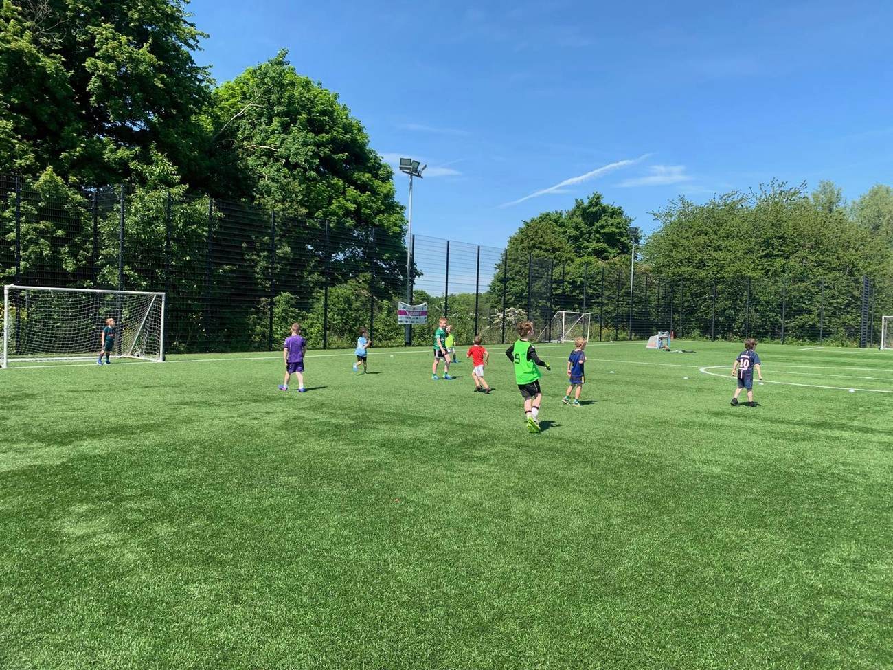 Children playing football on a large pitch during an Elevate Sports session
