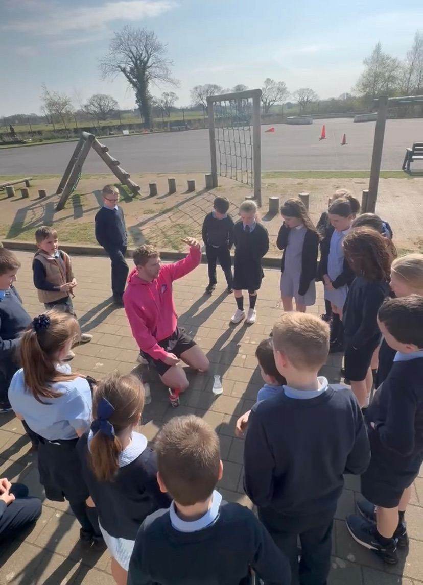 Elevate Sports coach leading an outdoor PE session with a class of primary school children