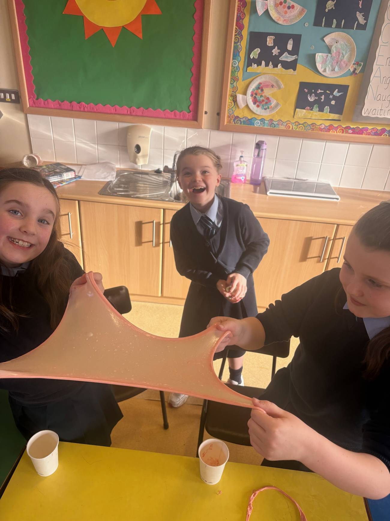 Children holding up a large piece of stretched slime during an Elevate Sports Slime party