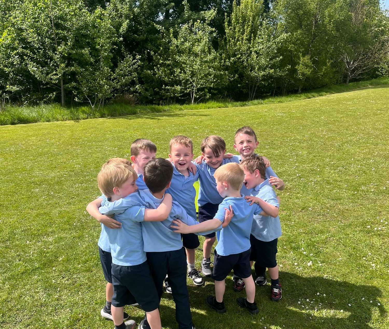 A group of primary school children in an excited team huddle during an Elevate Sports outdoor session